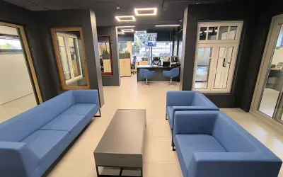 Nowoczesne wnętrze salonu okien i drzwi z niebieskimi sofami i stolikiem kawowym.