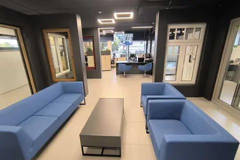 Nowoczesne wnętrze salonu okien i drzwi z niebieskimi sofami i stolikiem kawowym.